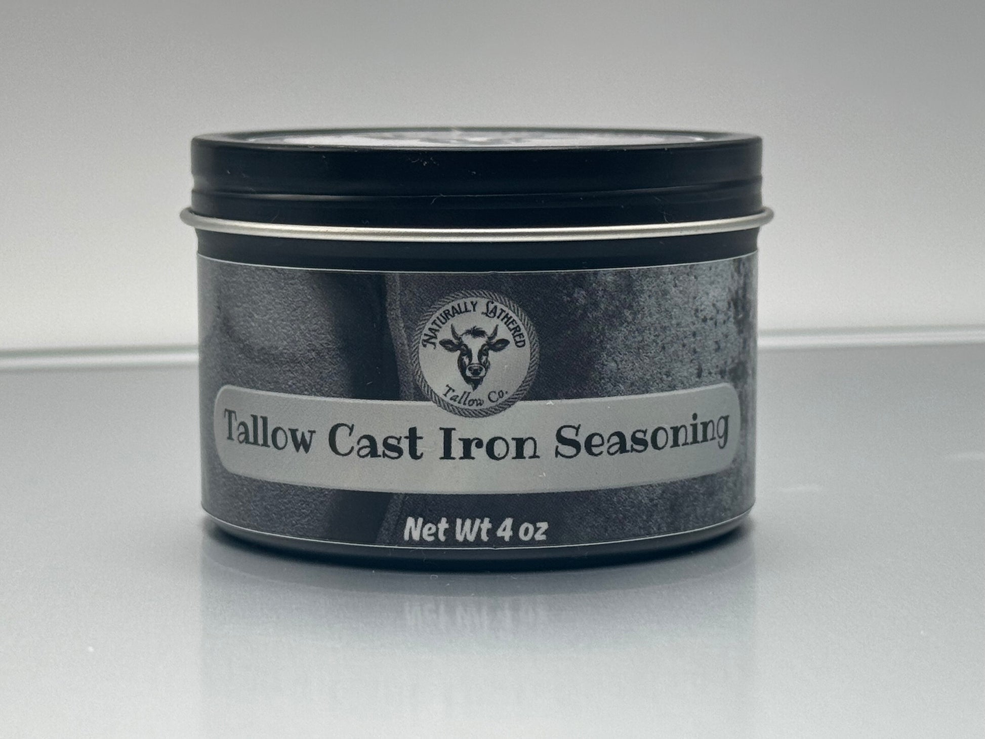 Tallow Cast Iron Seasoning container with label on a reflective surface
