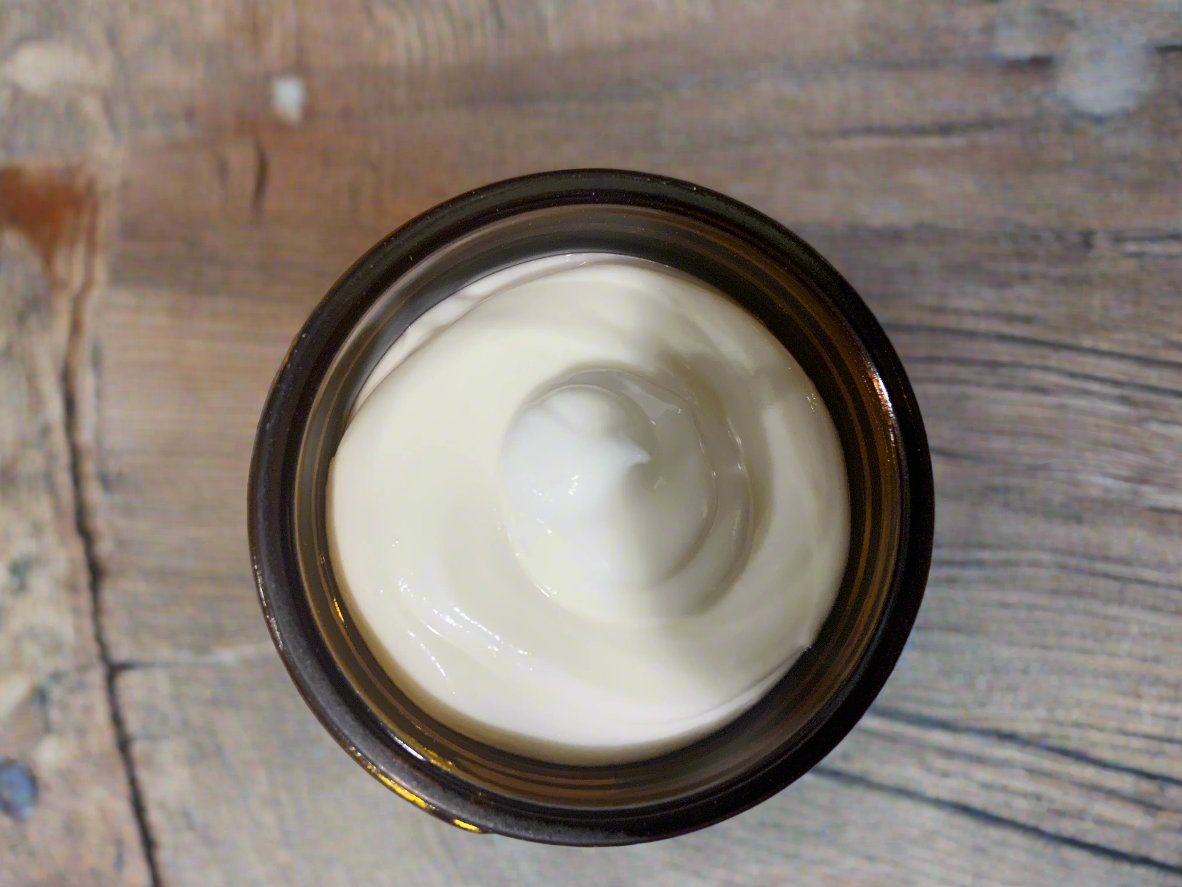 A jar of Unscented Whipped Tallow Balm by Naturally Lathered, showcasing the product label with some decorative elements in the background.
