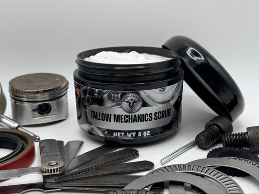 Jar of 'Tallow Mechanics Scrub' surrounded by mechanical parts on a light gray background