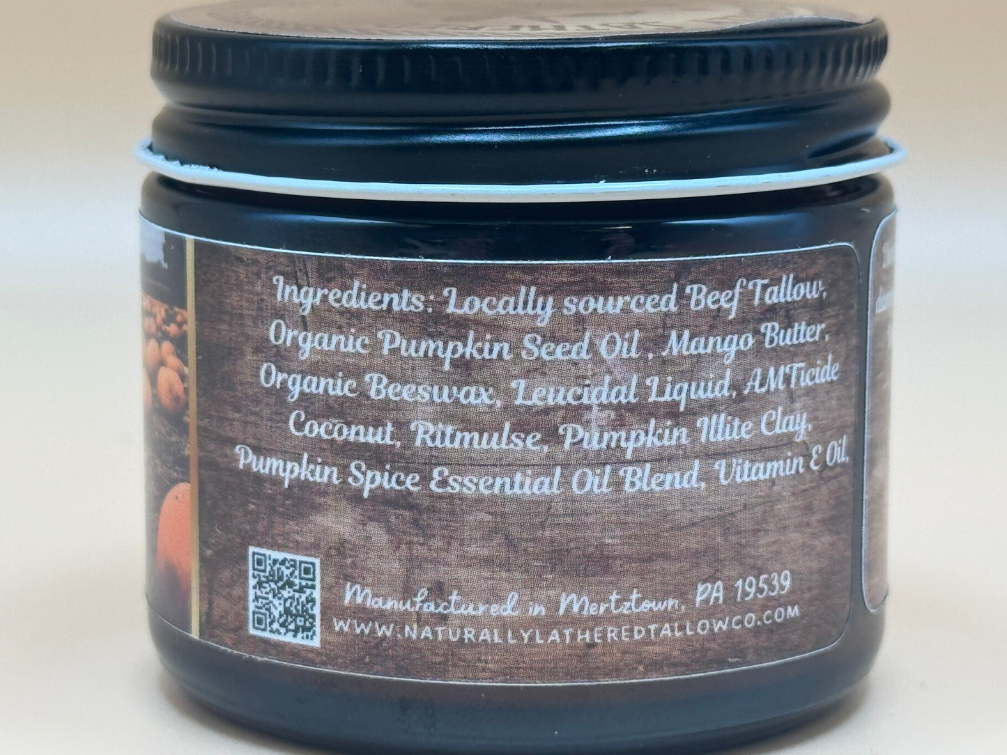 Jar with a label showing ingredients and manufacturing details on a neutral background