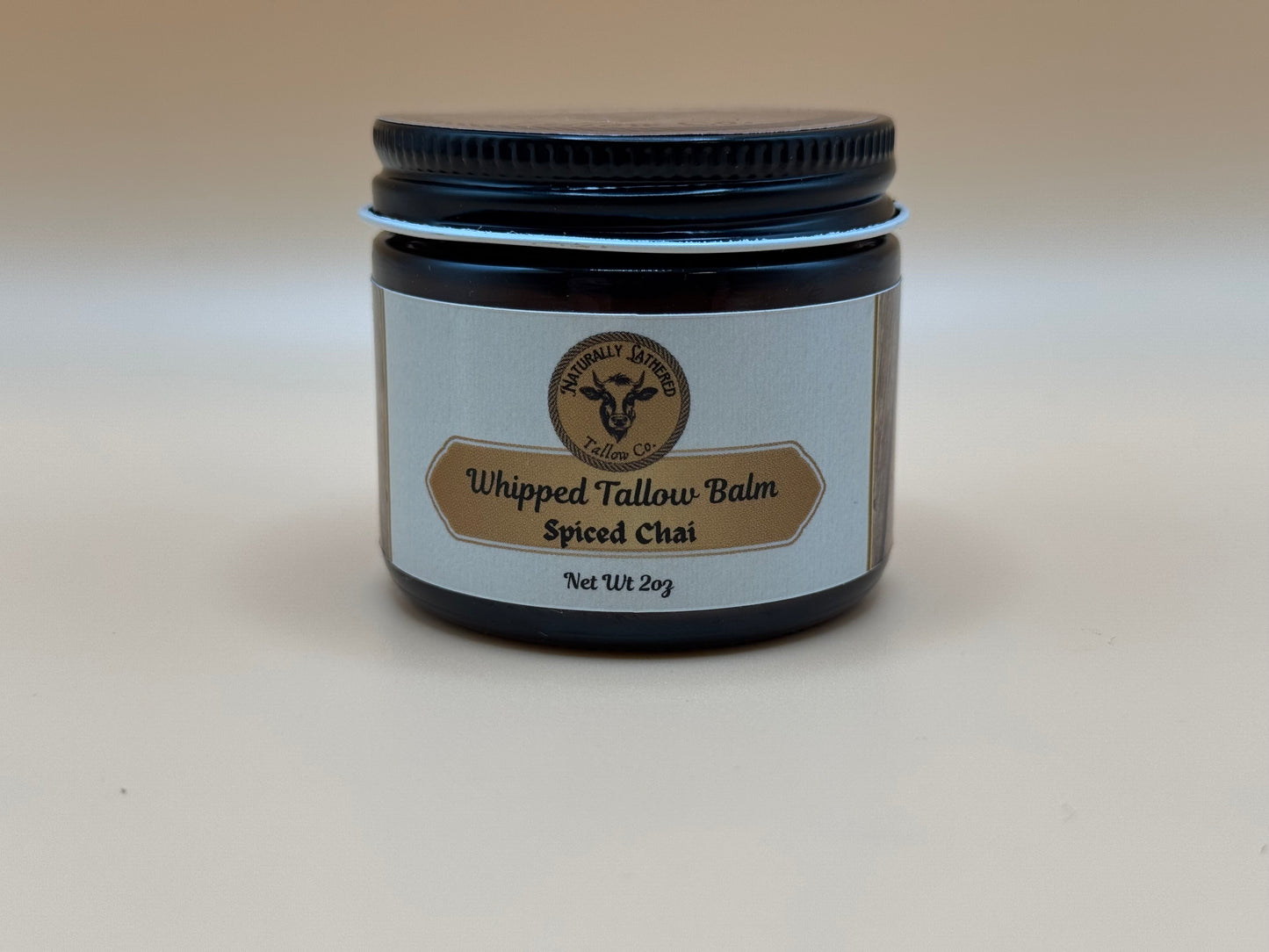 Jar of Whipped Tallow Balm with Spiced Chai scent on a beige background