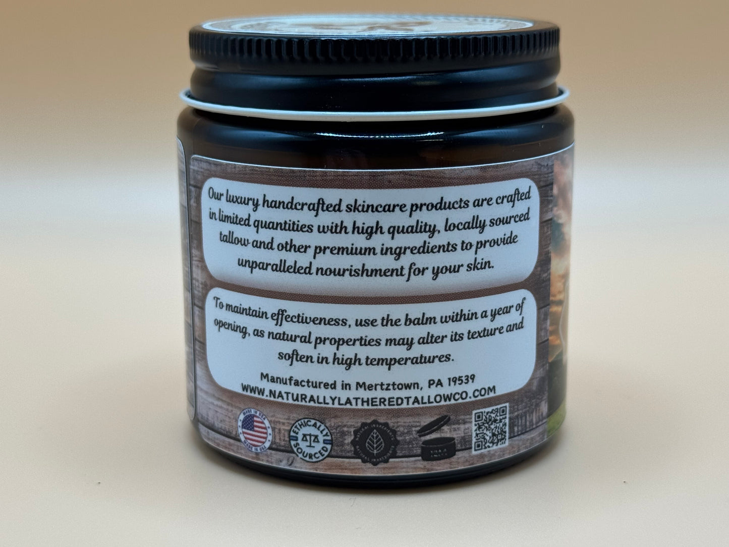 Jar of skincare product with a black lid and white label on a beige background